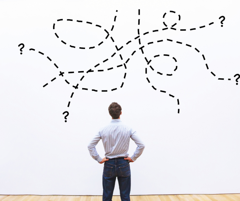 Person stands with hands on hips, looking at a whiteboard with a series of tangled, dotted lines and question marks.